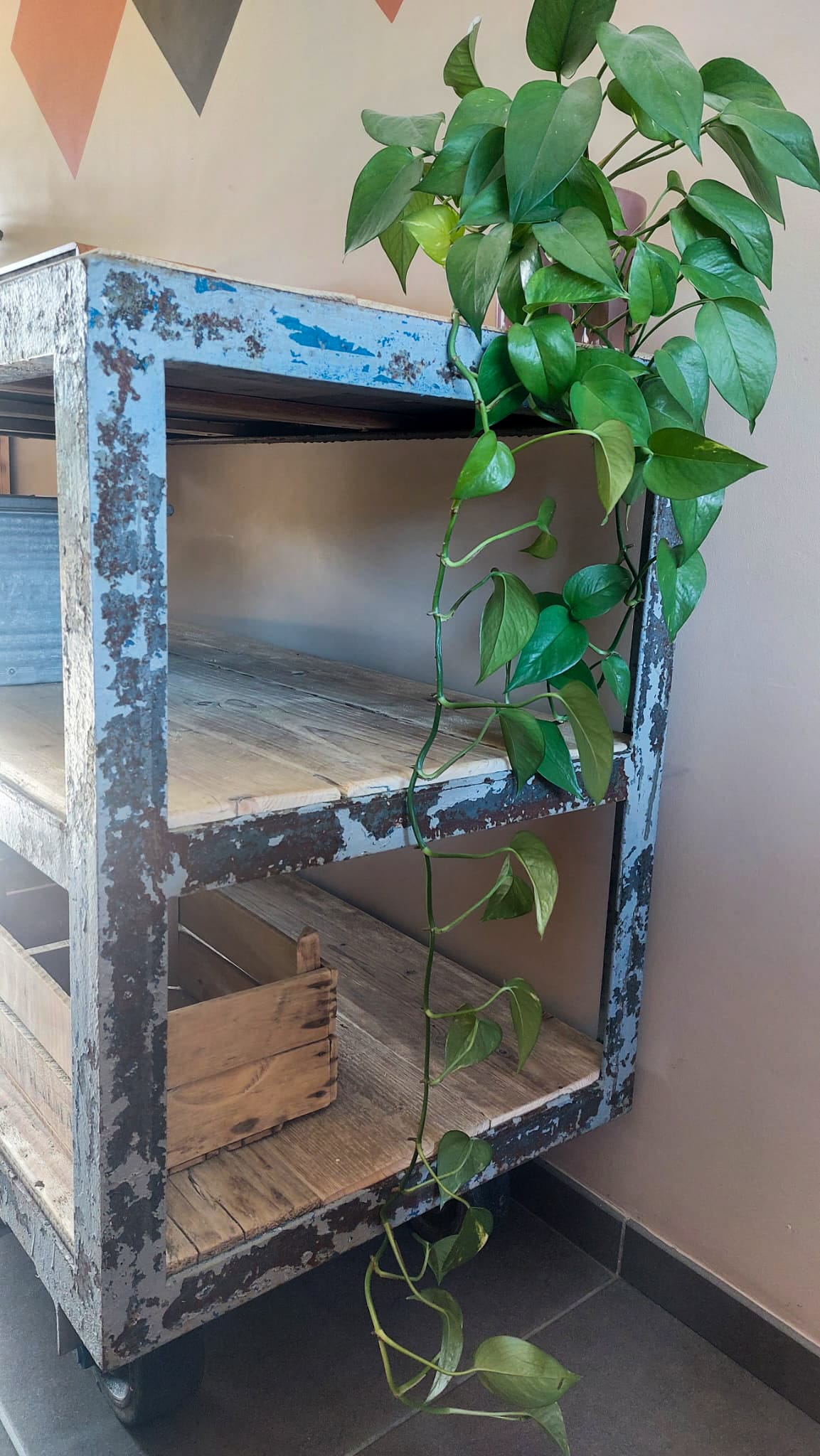 opgeknapte industriële kar, werkbank uit metaal afgewerkt met oud steigerhout met wielen